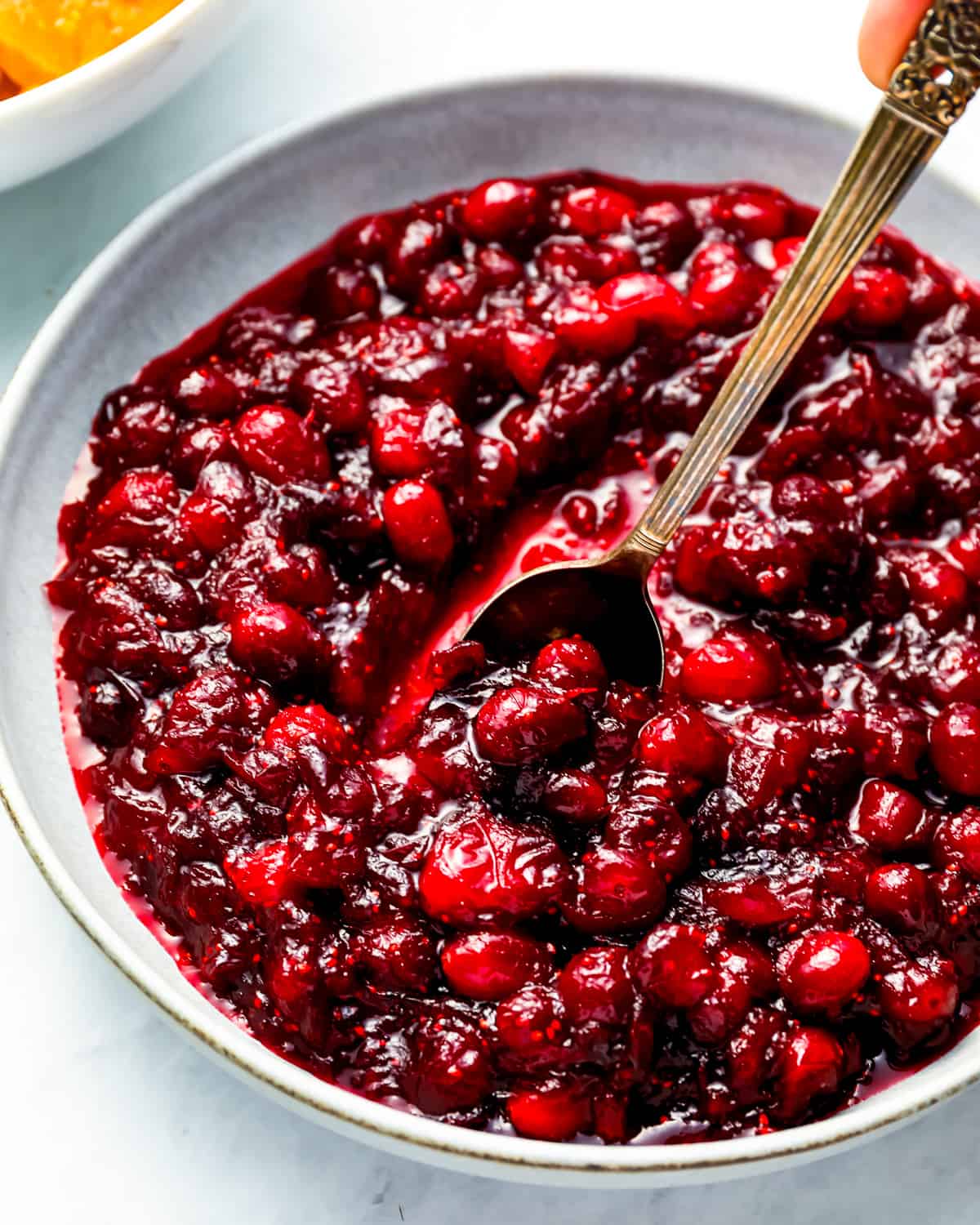 A bowl of cranberry sauce with a spoon.