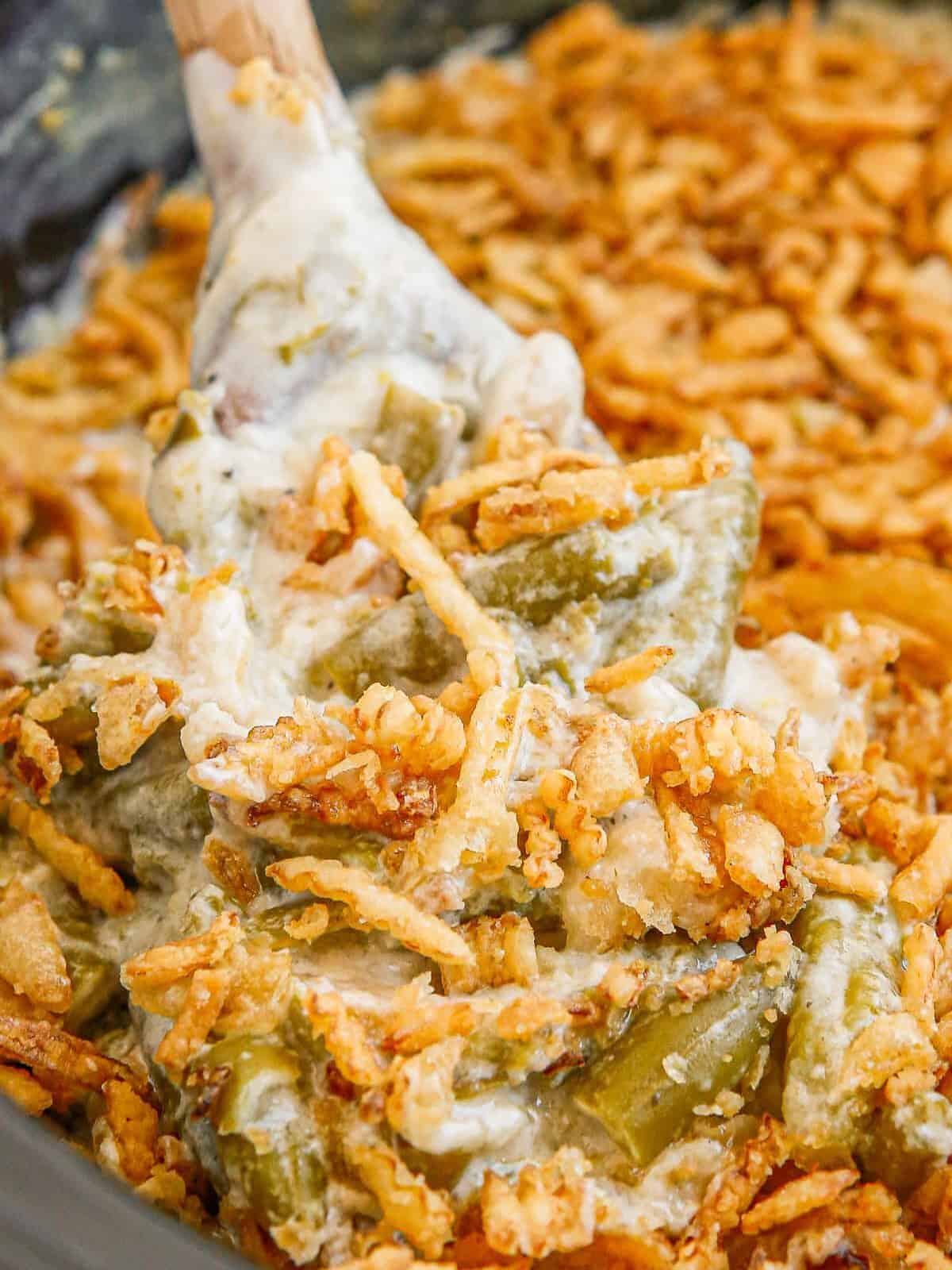 up close wooden spoon in crockpot green bean casserole