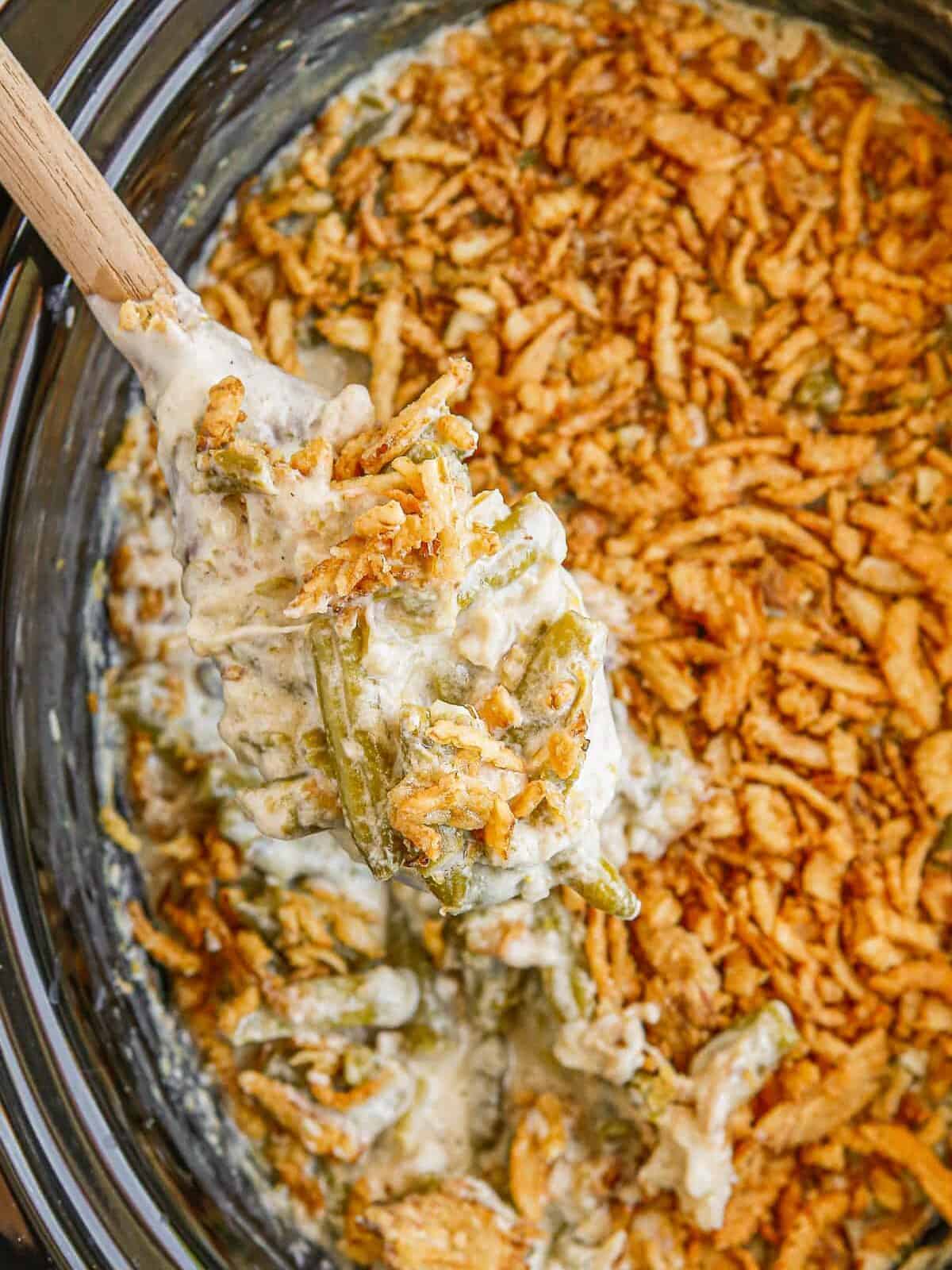 overhead wooden spoon in crockpot green bean casserole