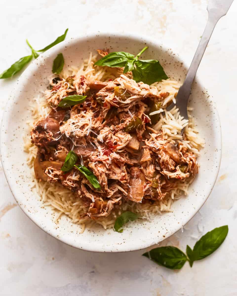 A white bowl with rice and meat in it.