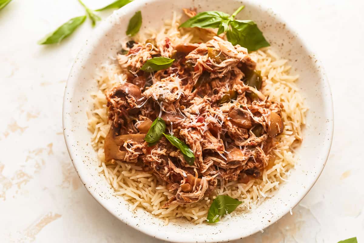 Pork tenderloin on rice with basil leaves.