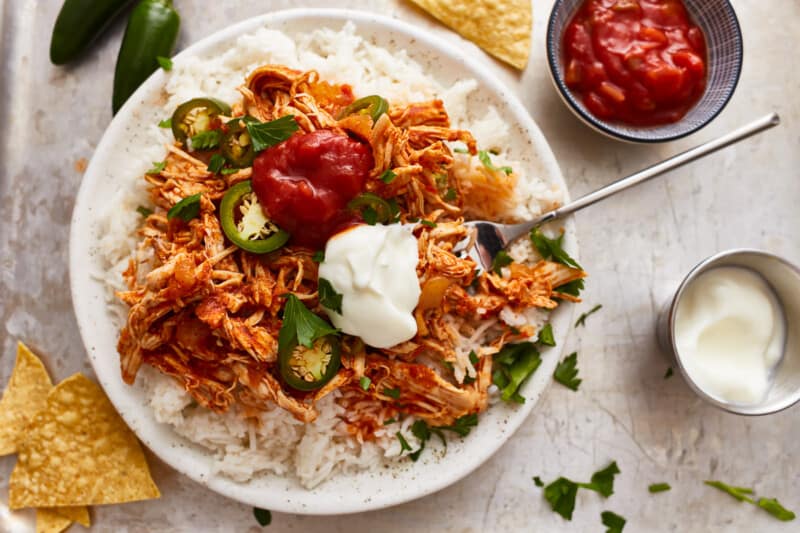 Mexican chicken rice with sour cream and salsa.