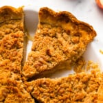A slice of apple pie with a crumb topping.