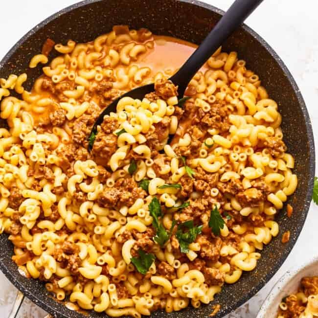 Macaroni and cheese in a skillet on a white background.