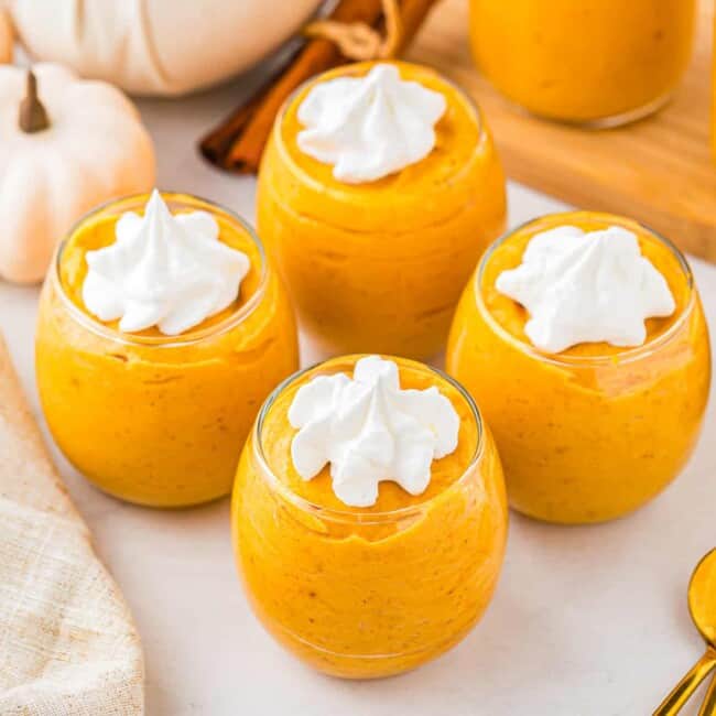 A bowl of pumpkin pudding with whipped cream.