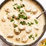 A pan with meatballs in a creamy sauce.