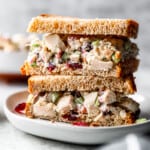 A stack of chicken salad sandwiches on a plate.