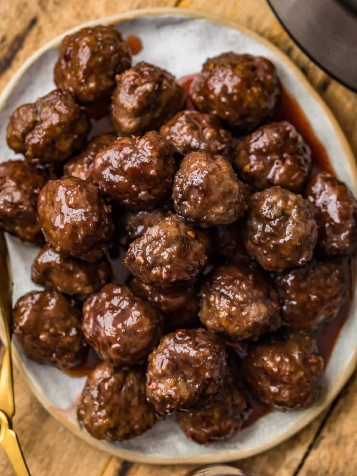 Grape Jelly Meatballs on a plate next to a slow cooker.