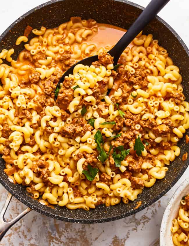 A skillet with macaroni and meat in it.