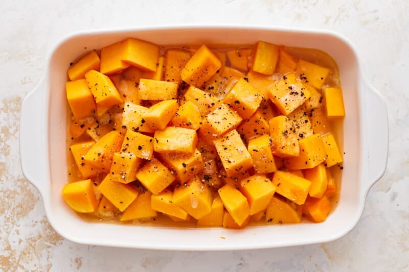 Squash cubes in a white baking dish.