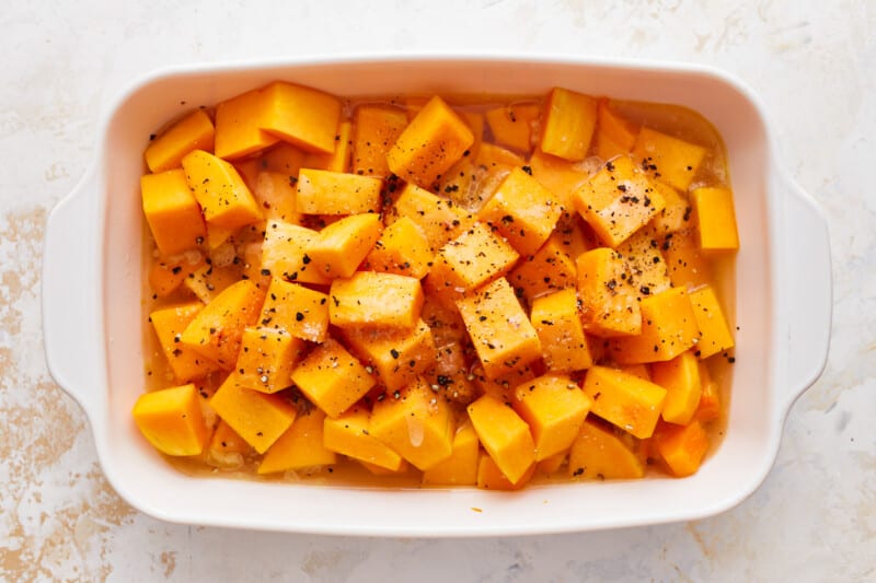 Squash cubes in a white baking dish.