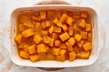 Roasted butternut squash in a white baking dish.