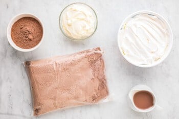 Chocolate mousse ingredients on a marble table.