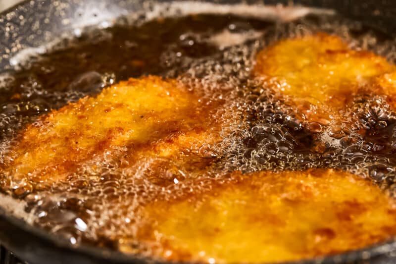 Fried fish fillets in a frying pan.