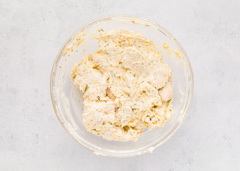 A bowl of mashed potatoes on a white background.