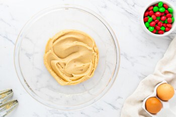 A bowl of peanut butter cookie dough on a marble table.