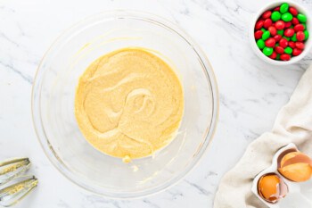 A bowl of batter with ingredients on a marble table.