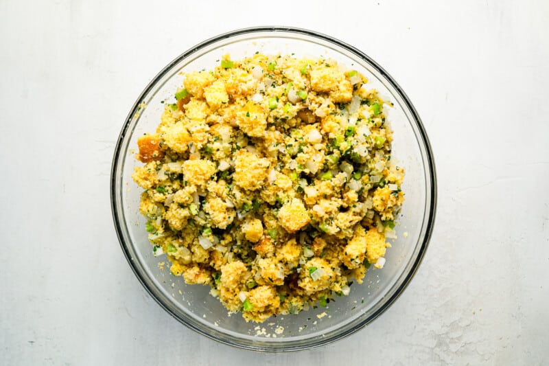 A bowl of cornbread stuffing on a white table.