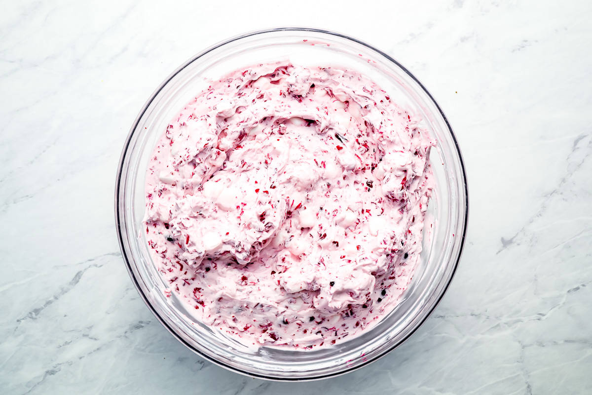 marshmallow fluff with cranberries mixed in a glass bowl.