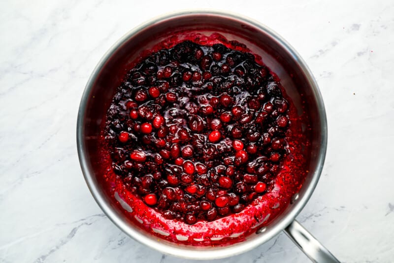 Cranberries in a pan on a marble countertop.