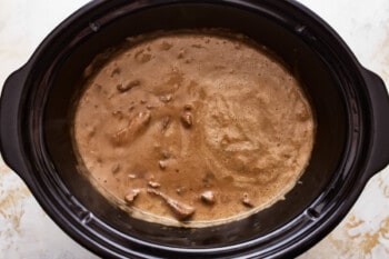 A crock pot filled with chocolate sauce.