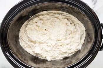 A bowl of white batter in a slow cooker.