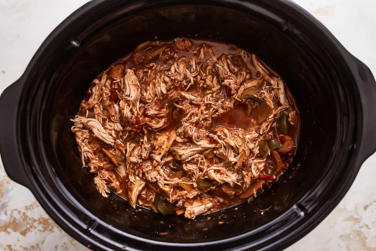 A crock pot full of shredded chicken.