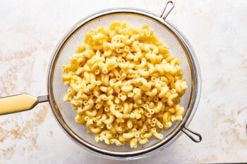 Macaroni and cheese in a strainer.