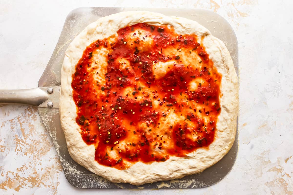 Pizza sauce spread on pizza dough.