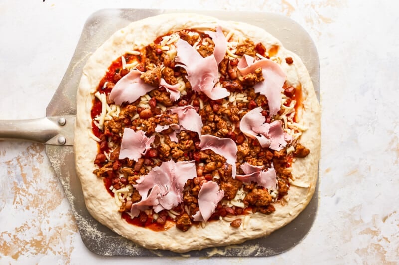 A pizza with ham and cheese on top.