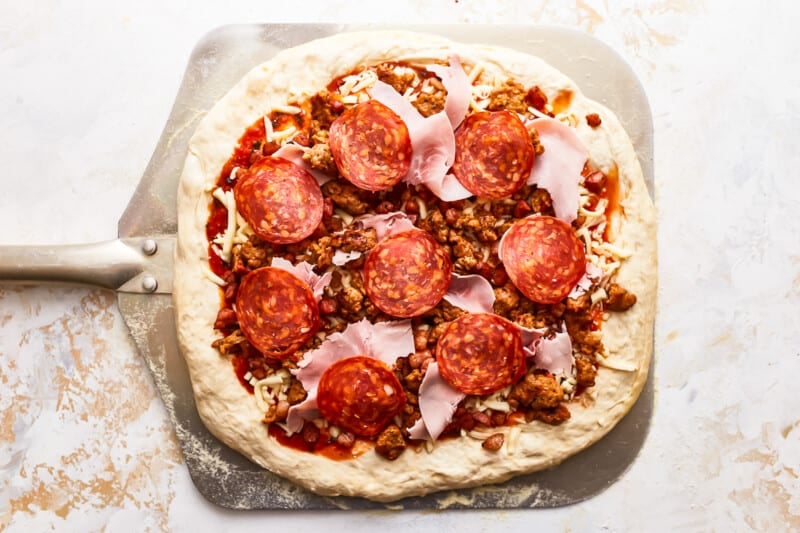 A pizza with pepperoni and sausage on top.