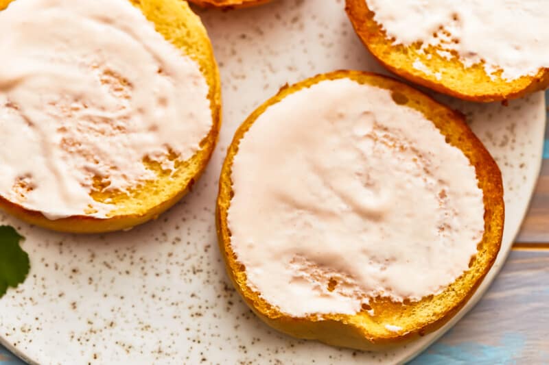 Four slices of pumpkin with icing on a plate.