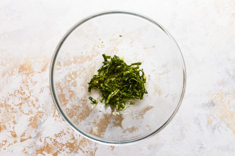 A glass bowl filled with green herbs.