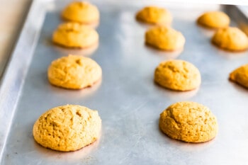 Pumpkin cookies on a baking sheet.