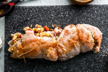 A stuffed chicken breast on a cutting board.