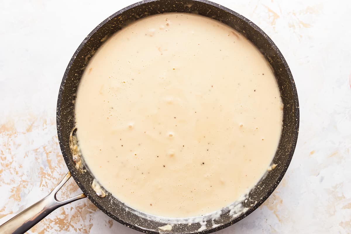 Adding ingredients to make the Swedish meatball sauce. 
