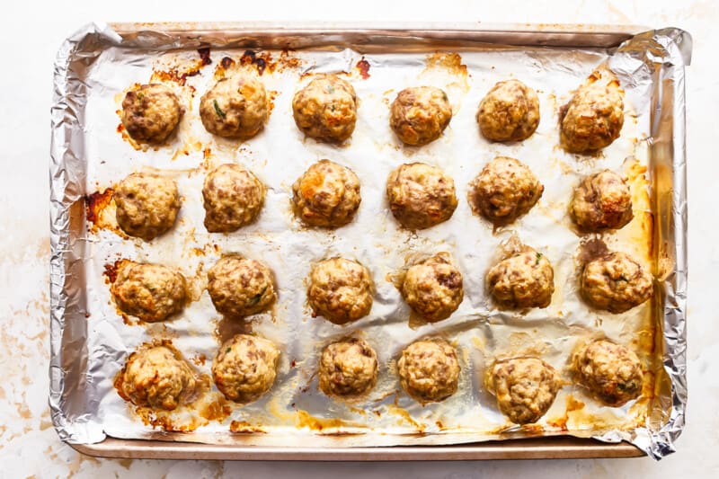 A baking sheet with meatballs on it.
