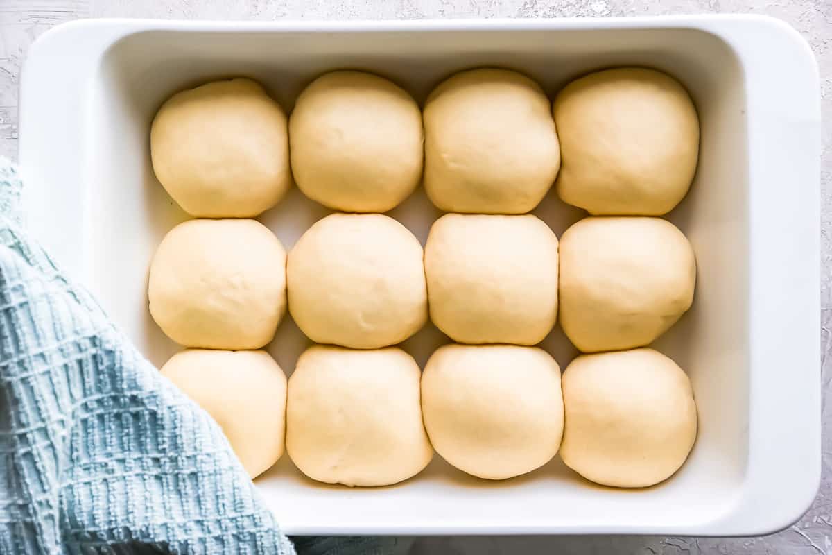 Dough balls in a baking dish on a table.