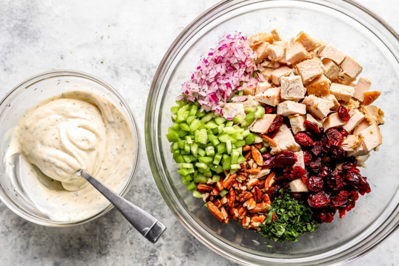 A bowl full of ingredients for a cranberry chicken salad.