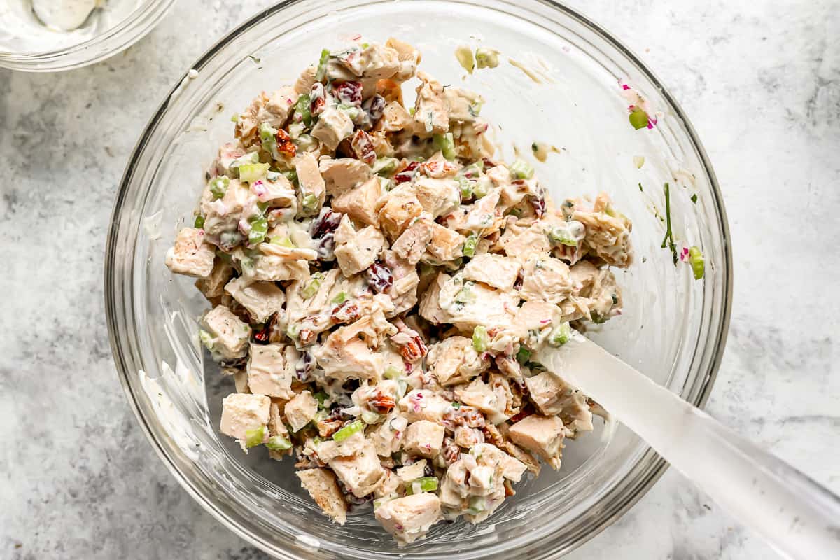 Turkey salad mixture in a glass bowl with cranberries.