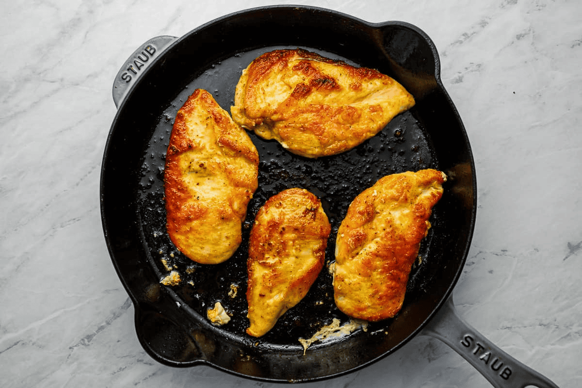 chicken breasts browning in a pan