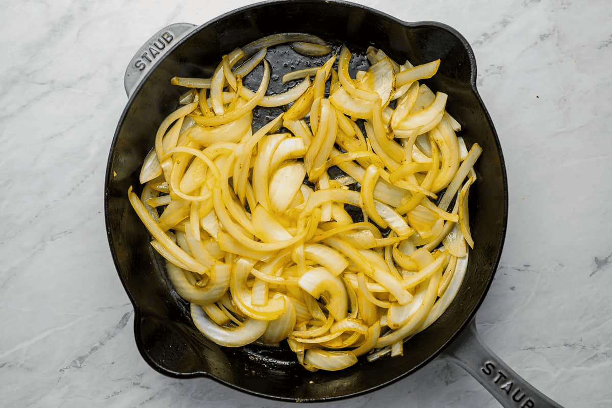 sliced onions cooking in a pan