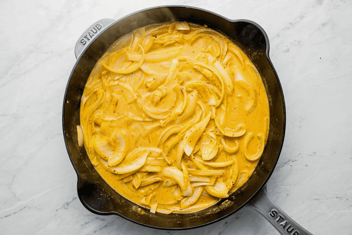cream mixed into onions cooking