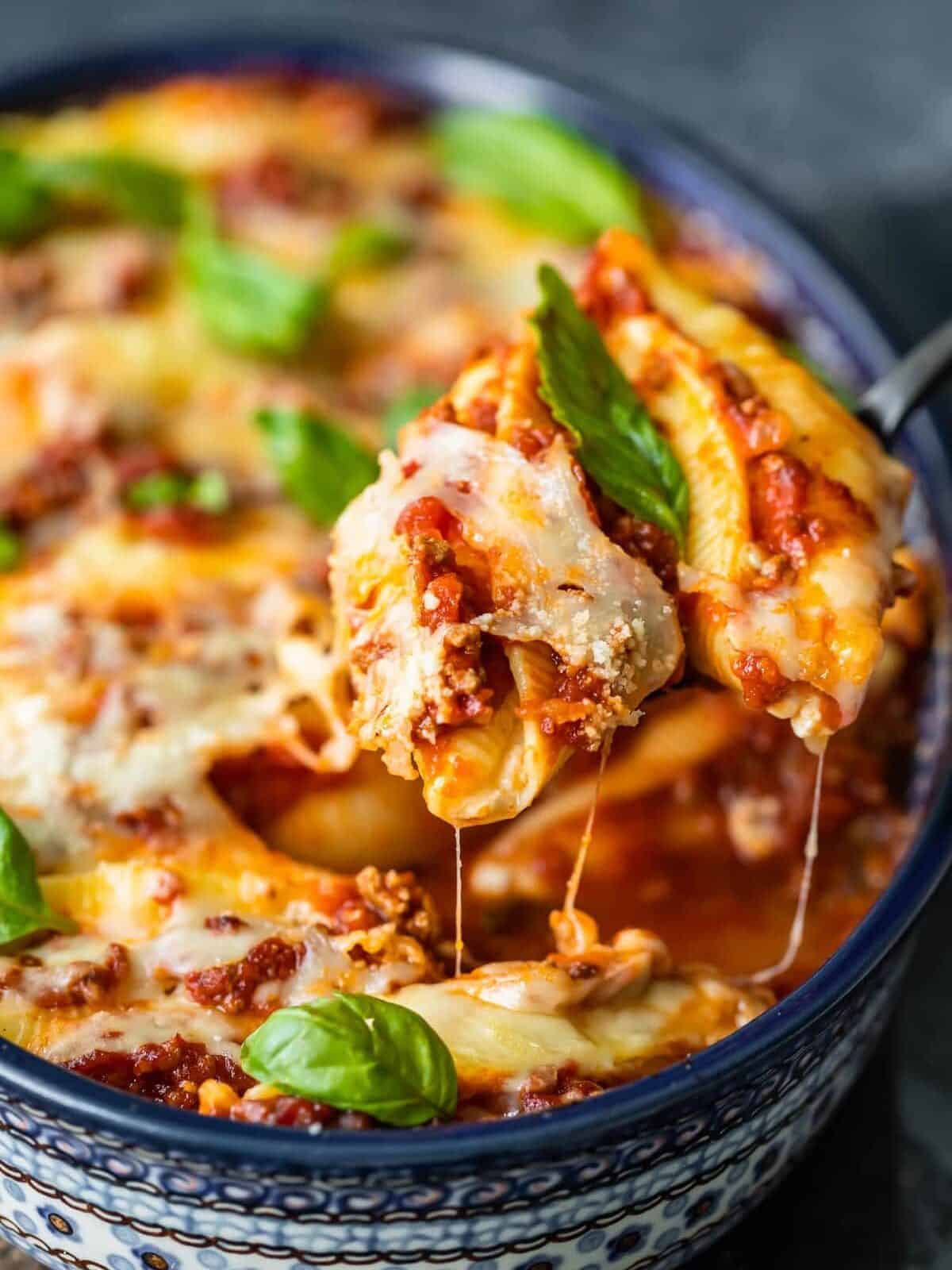 close up image of pasta shells stuffed with cheese and topped with meat sauce