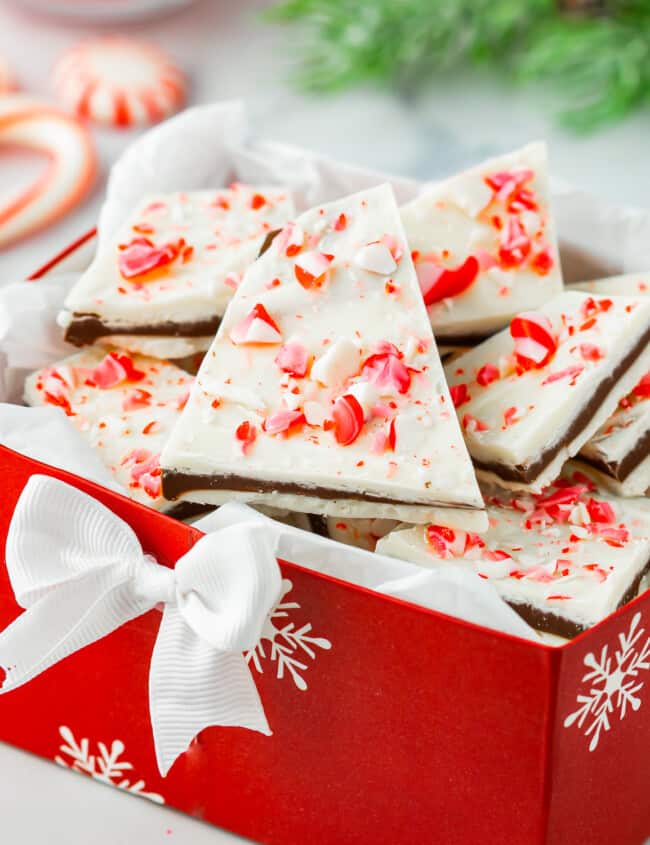 Peppermint bark in a red box with candy canes.