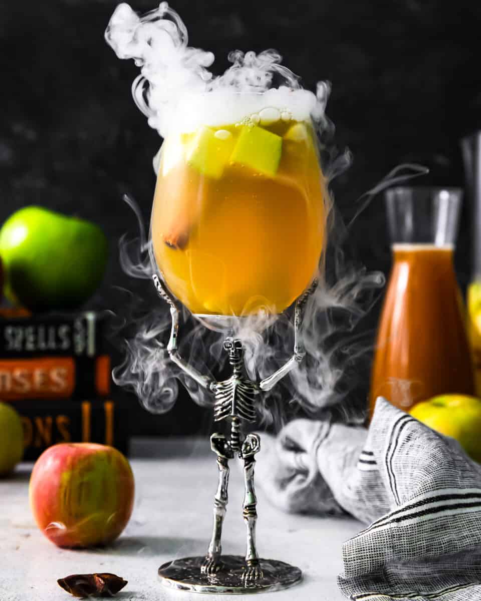 Smoking poison apple sangria in a novelty skeleton glass.