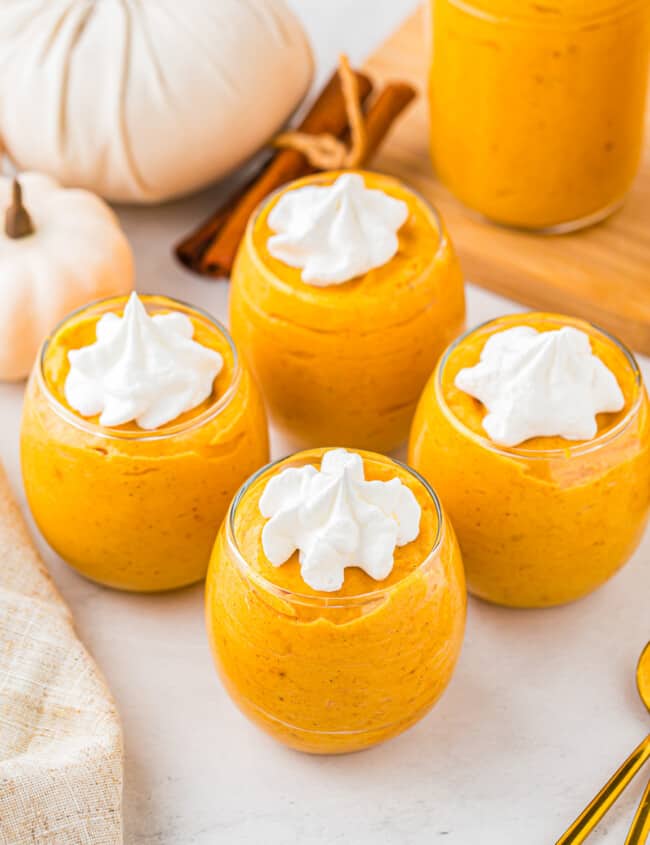 Pumpkin pudding in jars with whipped cream on top.