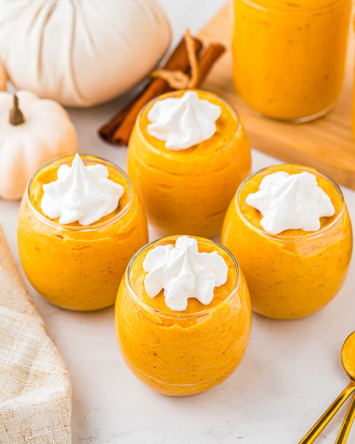 Pumpkin mousse in jars with whipped cream on top.
