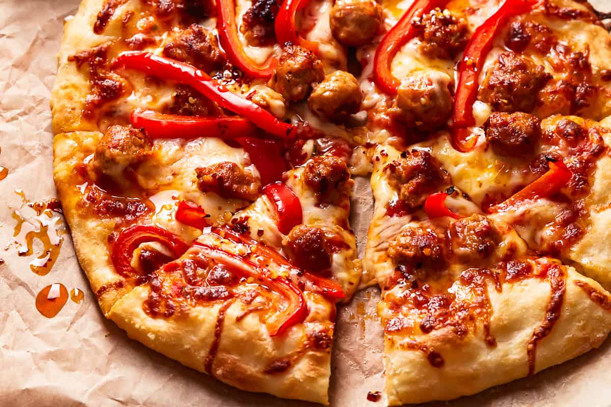 A pizza with sausage and peppers on it.