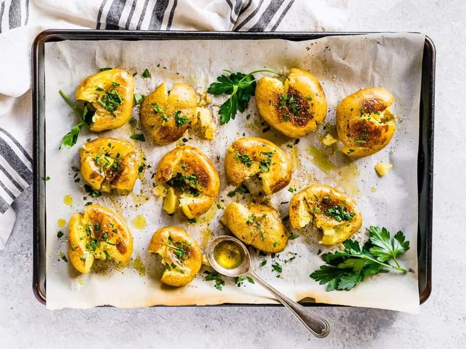 seasoned smash potatoes on a baking sheet